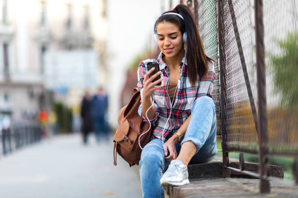 ragazza che sms su smartphone in città - music listening child smiling foto e immagini stock