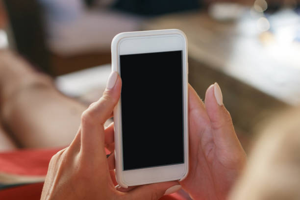 istock White smartphone with blank screen in female hands close up 914482150