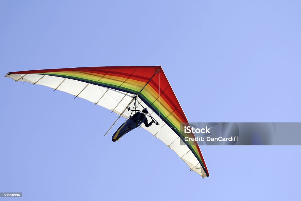 A person hang gliding on a clear day Hang glider with clear blue sky,San Francisco,Ca. Rainbow colors.Click for more action. Hang Glider Stock Photo