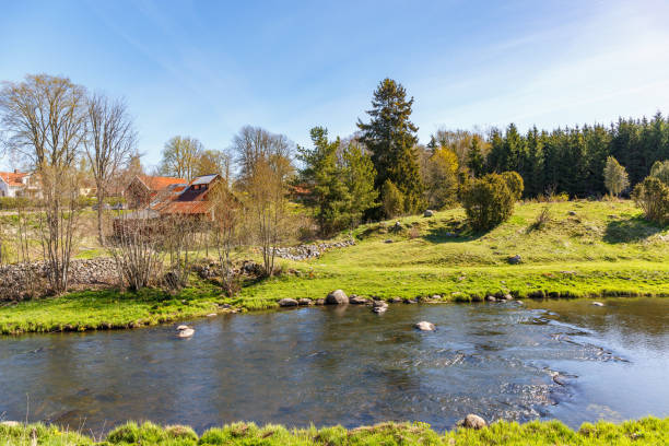 istock River flowing through a rural landscape along a village 914485568