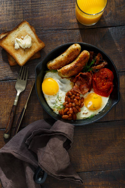 istock Full English breakfast on a dark wooden table, top view 914485936