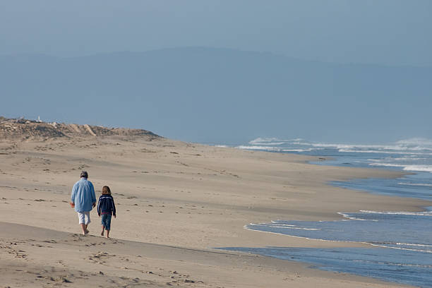 istock Mother and Daughter Stroll on Beach 91448742