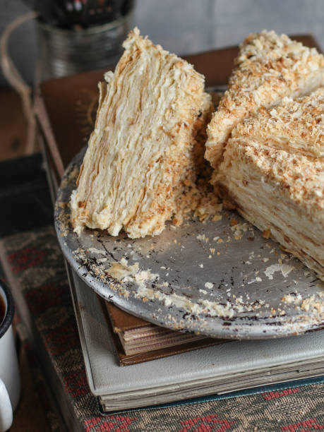 istock cake - Napoleon (cake with white cream is layered) and photos on a wooden table 914487446
