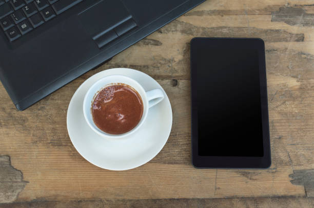 istock Laptop, tablet and coffee cup on old wooden table. 914489952