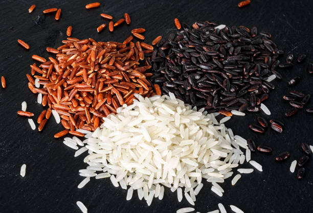 istock Jasmine rice, Red rice, Black rice on black stone background 914490180