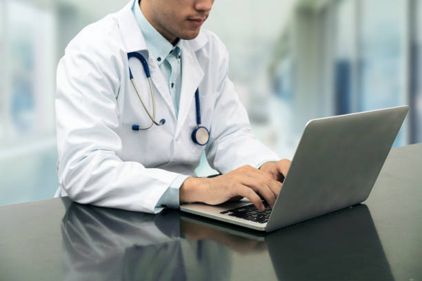istock Doctor working on desk with laptop 914490856