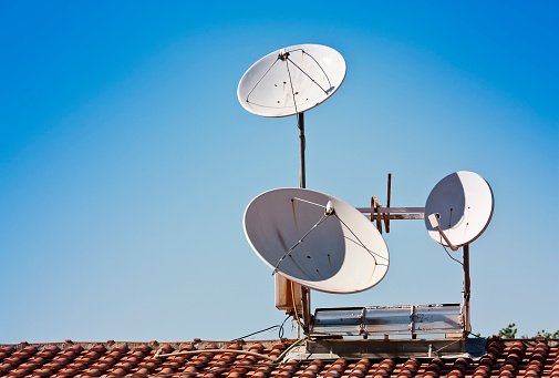 Dish antenna on a home roof as cable broadcasting receiver