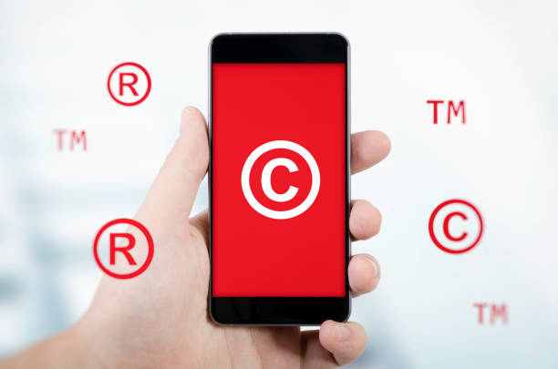 istock Copyright, trademark symbols flying around smartphone. 914497376