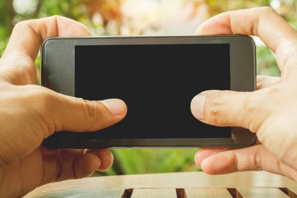 istock Close up of hands holding telephone copy space with sunset background. 914497498