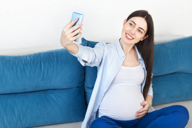 istock pregnant woman taking selfie 914501442