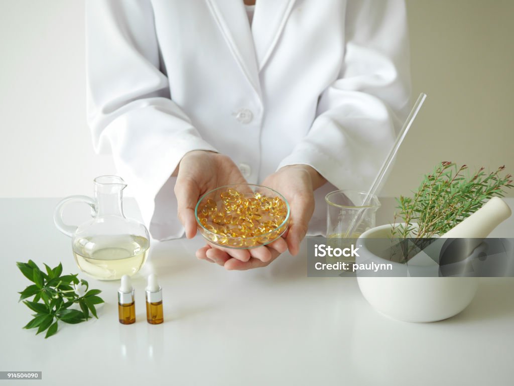scientist or doctor making herbal medicine with herb leaves , capsule, tablets.hands. Homeopathic Medicine Stock Photo