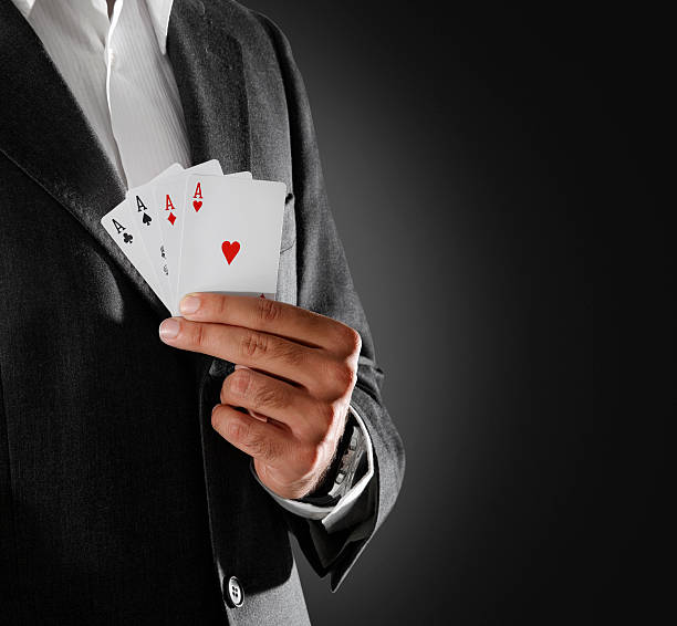 istock Man in a dark jacket holding playing cards with four aces 91451402