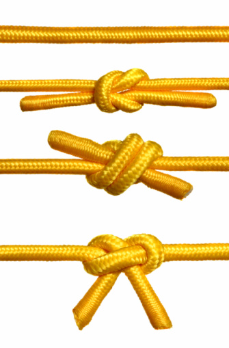 Closeup shots of a rope with a knot. Isolated white background. 