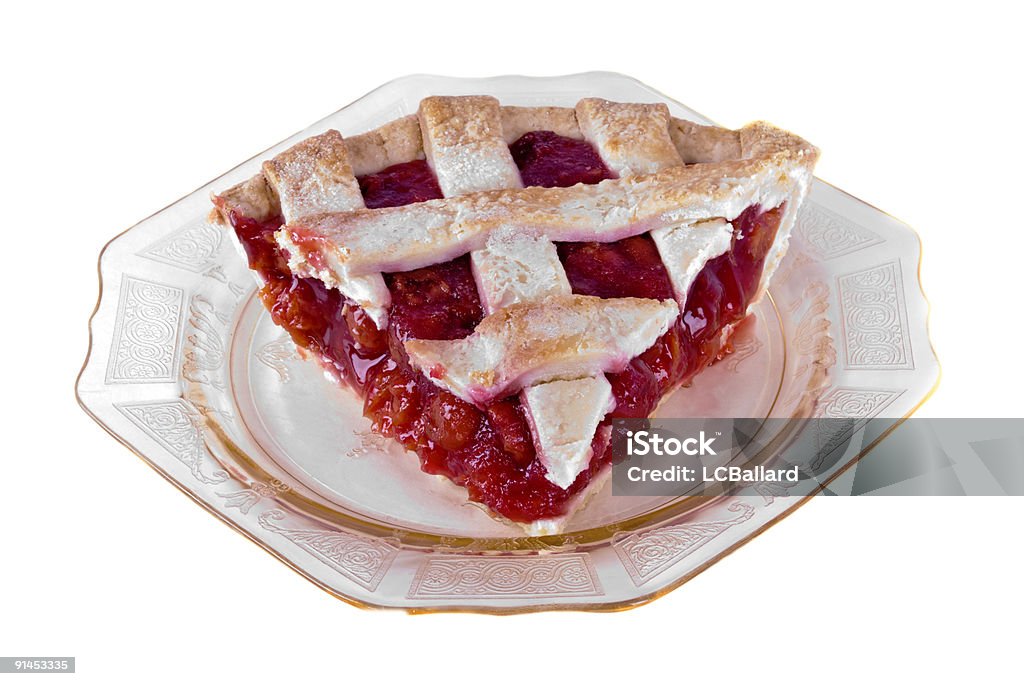 Slice of homemade cherry pie served on antique glass plate Serving of homemade cherry pie covered with a lattice crust. The see through gold colored glass plate is an antique. The entire image is isolated on a white background.  Baked Stock Photo