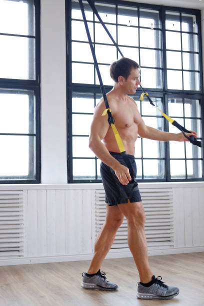 um homem fazendo exercícios com expansor. - abdominal muscle muscular build barbell bicep - fotografias e filmes do acervo