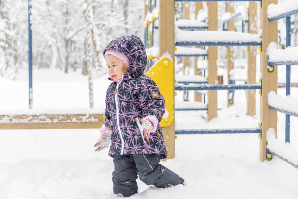 istock Unhappy baby girl walks during snowfall 914538600