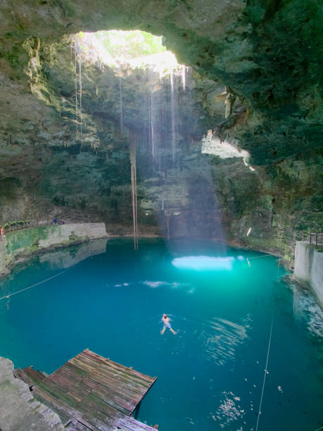 istock Young man swimming in Cenote sink hole Hukib 914540830