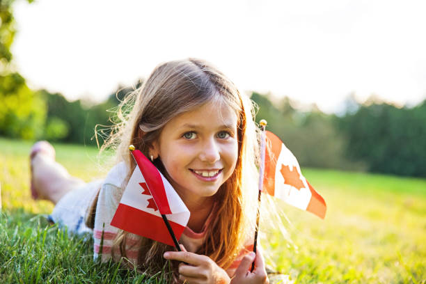 canada day - patriotische kleine mädchen mit der kanadischen flagge - canada day fotos stock-fotos und bilder