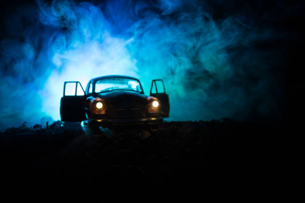 Silhouette of old vintage car in dark foggy toned background with glowing lights in low light, or silhouette of old crime car dark background. Silhouette of old vintage car in dark foggy toned background with glowing lights in low light, or silhouette of old crime car dark background. Selective focus couple driving at night stock pictures, royalty-free photos & images