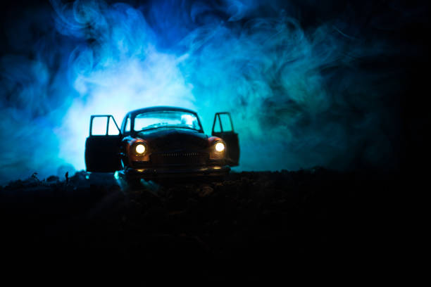 sylwetka starego zabytkowego samochodu w ciemnym mglistym tle stonowanym z świecącymi światłami w słabym świetle lub sylwetką starego samochodu kryminalnego ciemne tło. - summer landscape flash zdjęcia i obrazy z banku zdjęć