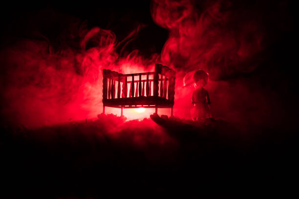 stare straszne niesamowite drewniane łóżeczko dla dzieci w ciemnym stonowanym mglistym tle. koncepcja horroru. przerażająca sylwetka dziecka i łóżka w ciemności - doll evil child baby zdjęcia i obrazy z banku zdjęć