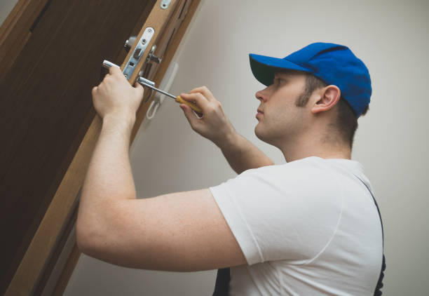 istock Young handyman in uniform changing door lock. 914545818