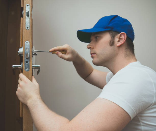 istock Young handyman in uniform changing door lock. 914545824