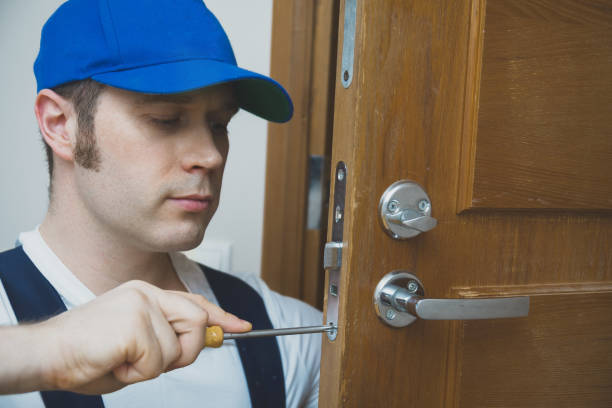 istock Young handyman in uniform changing door lock. 914545846
