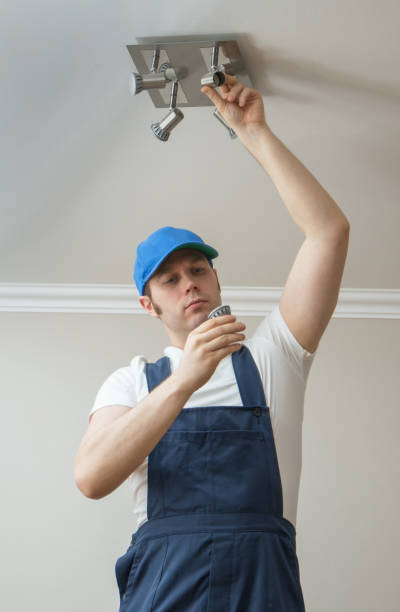 istock Handsome male electrician changing the light bulb. 914545966