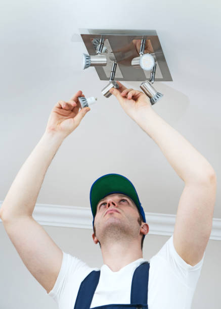 istock Handsome male electrician changing the light bulb. 914545986