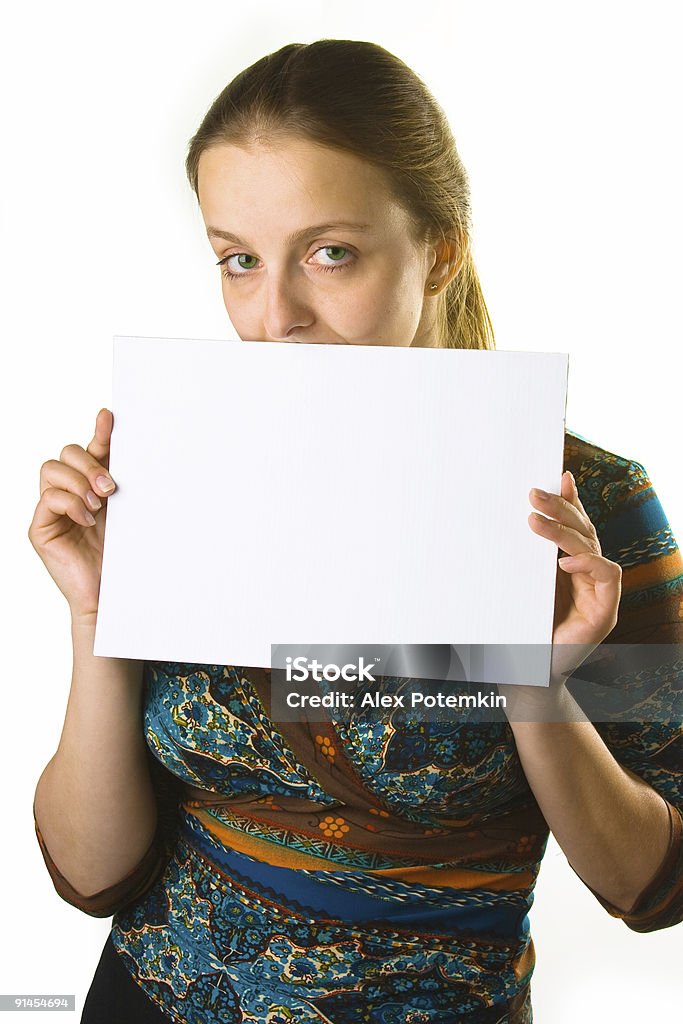 Young woman holding white name board Change the white table in the girl's hands to Your own text, products or picture! Adult Stock Photo