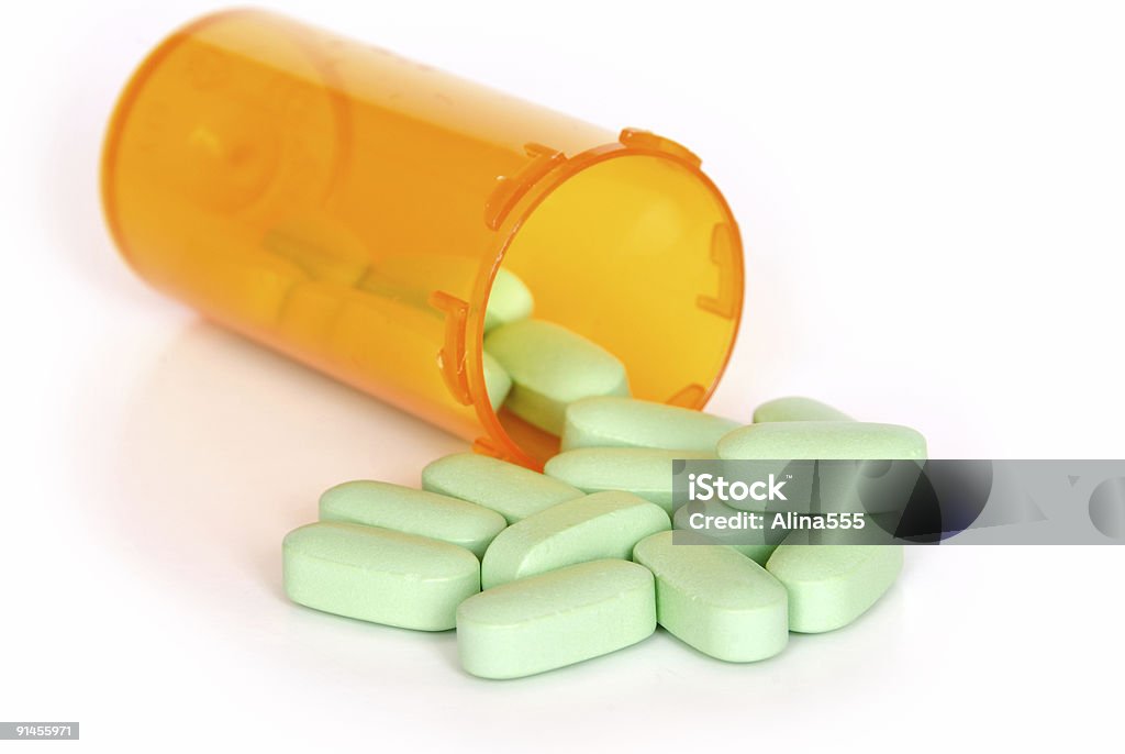 Verde com frasco de comprimidos de vitaminas laranja em branco - Foto de stock de Comprimido royalty-free