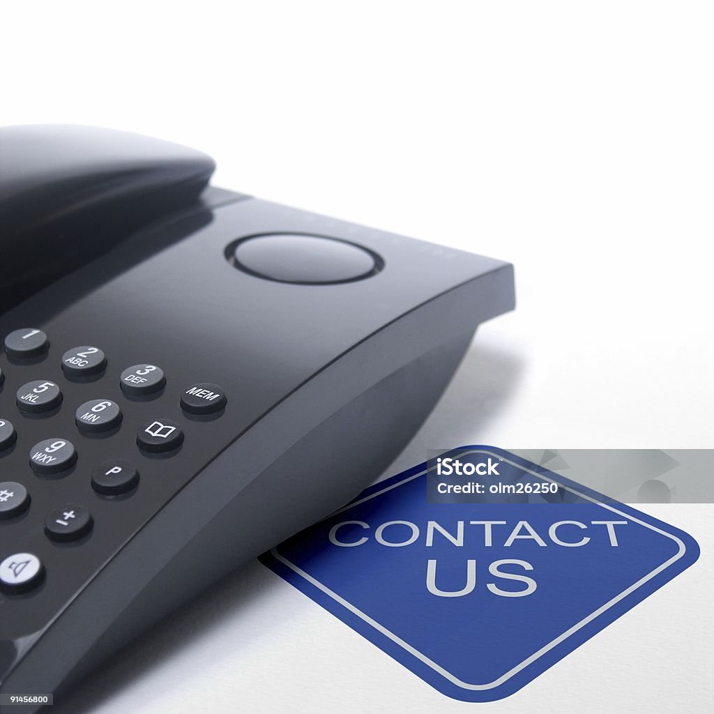 contact us sign with black telephone black telephone isolated on a white background with a blue contact us sign Contact Us Stock Photo