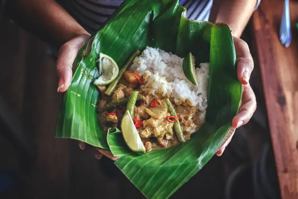 Photo of Indonesian Chicken Curry Dish with Rice Served on Banana Leaf