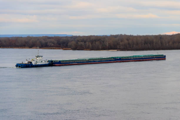 istock Tugboat pushing a heavy long barge on the river Dnieper 914571038