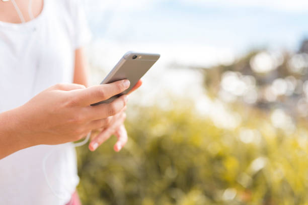 istock Young woman using smart phone at the beach after workout 914575274