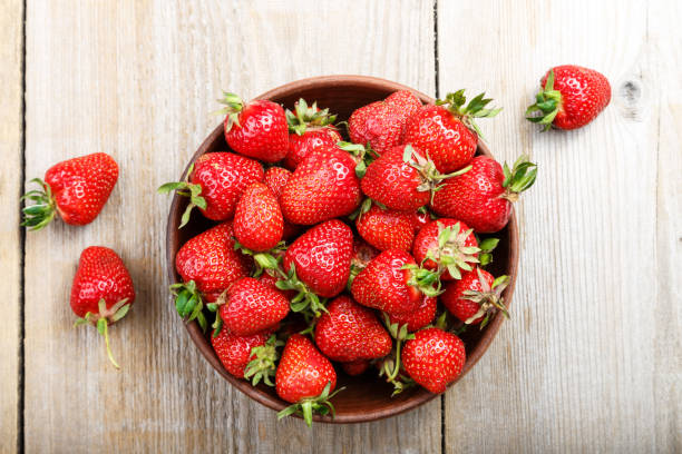 istock Fresh strawberry in a clay plate  on wooden table 914584182