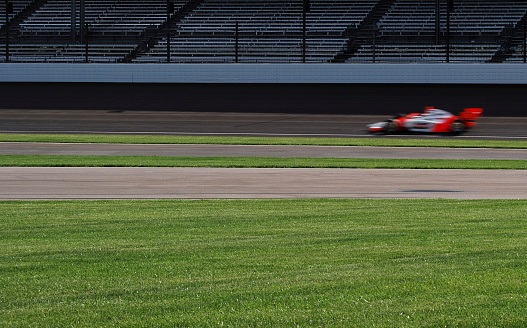 A race car speeds around turn 1 at the Indianapolis Motor Speedway.