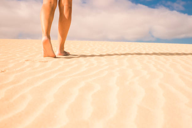 istock barefoot woman legs walking on the sand 914589916