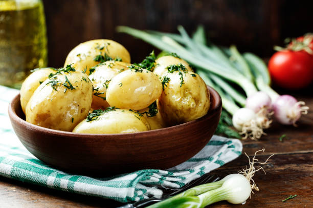 istock Summer dinner set with potatoes, summer vegetables, with young onions and tomatoes. 914593856