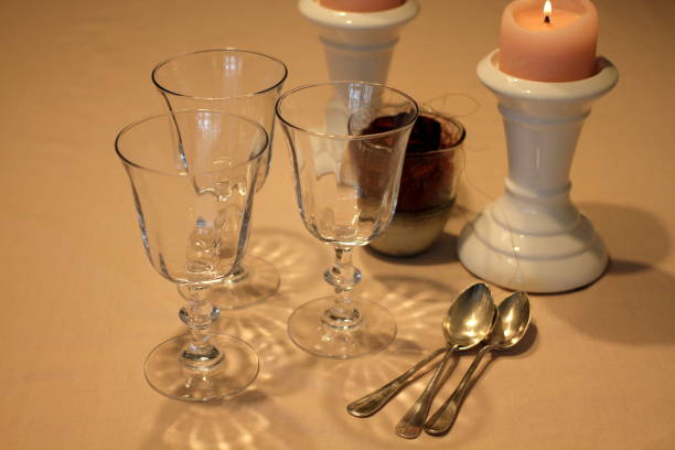 istock Romantic table with candles, red rose, plate, empty wine glasses and coffee spoons 914594218