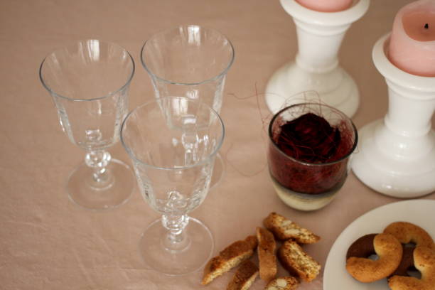 Romantic table with candles, red rose, plate, empty wine glasses and biscuits