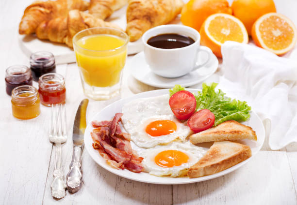 istock breakfast with fried eggs, croissants, juice, coffee and fruits 914599720