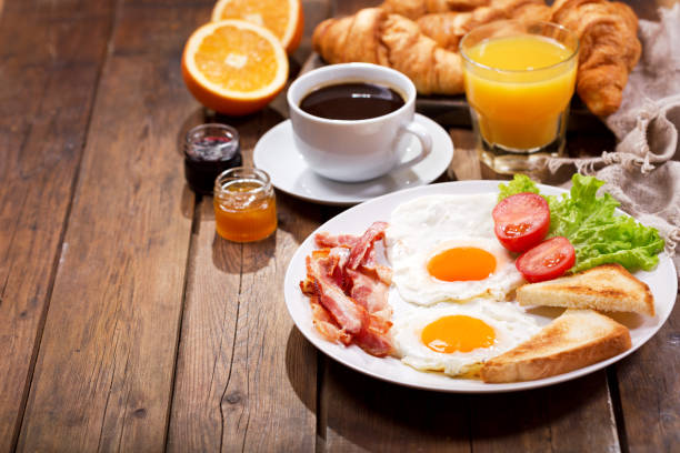 istock breakfast with fried eggs, croissants, juice, coffee and fruits 914599754