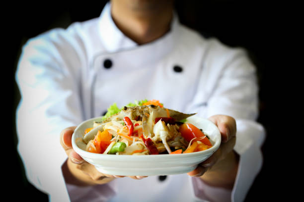 Chef proudly presenting Thai spicy crab papaya salad - Lao, Isan cuisine stock photo