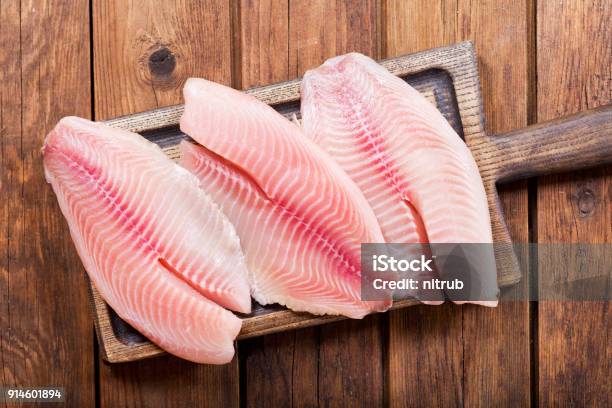 Foto de Filé De Peixe Fresco Na Placa De Madeira e mais fotos de stock de Tilapia Aurea - Tilapia Aurea, Cortado em Filé, Peixe