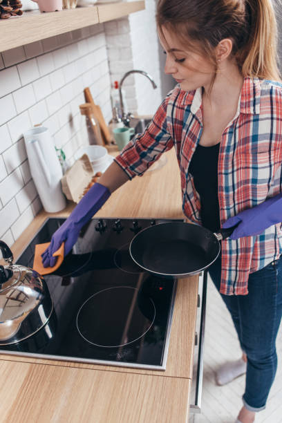 istock Young woman cleaning countertop in the kitchen 914602744