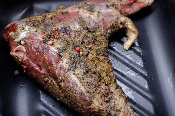 istock Raw uncooked lamb shank with herbs and spices in baking tin. Ready for cook. Close up. 914605842