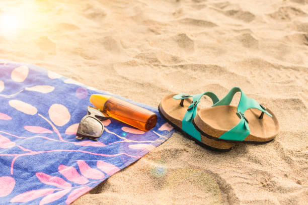 istock A bottle of sunscreen on a beach towel with flip flops 914609026
