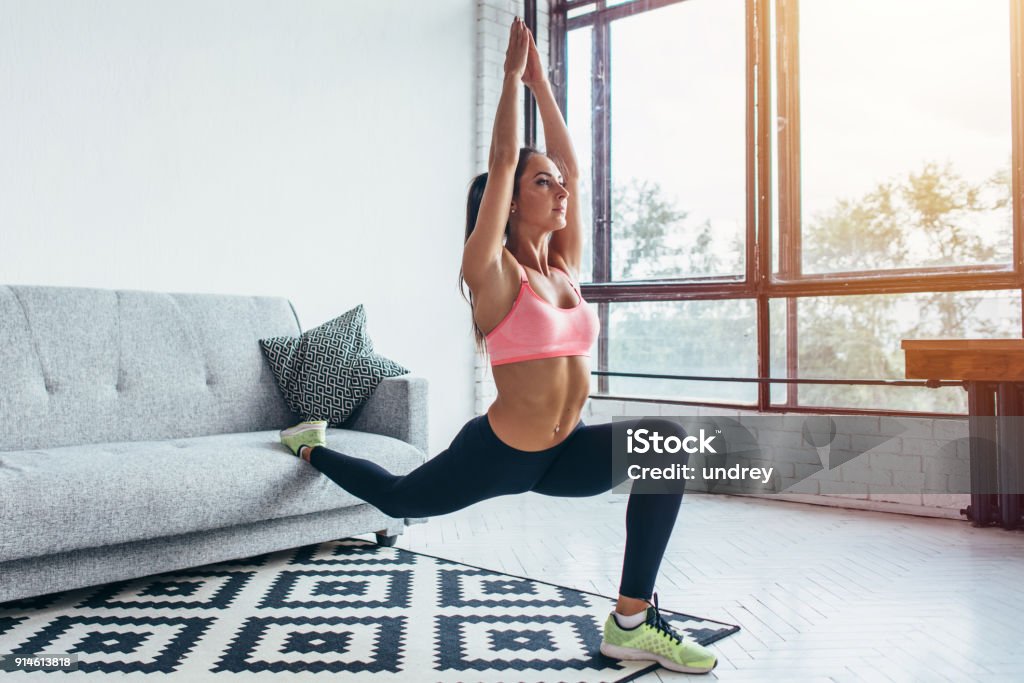 Fit woman doing front forward one leg step lunge exercises workout Fit woman doing front forward one leg step lunge exercises workout. Exercising Stock Photo